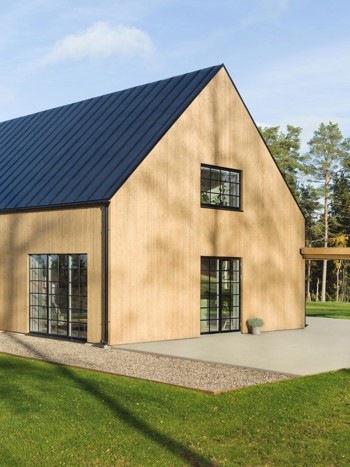 Trähus med svarta spröjsade fönster