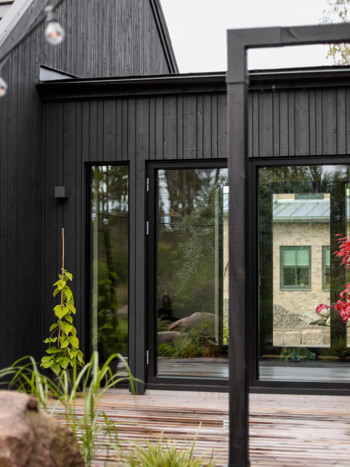 Svart ladhus med stora fönster